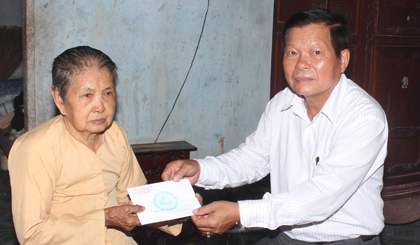 Chairman of the Provincial People’s Committee Nguyen Van Khang presented gift to Le Thi Hai in Trung An commune.