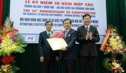 Professor Shin Hyu-Geun (centre) receives the Health Ministry’s insignia ‘For People’s Health’. 