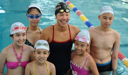 Anh Vien (centre) meets with young swimmers in Hanoi before leaving for training in the US.