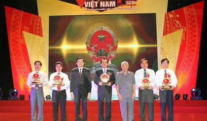 State President Truong Tan Sang (third from left) and former Party General Secretary Le Kha Phieu (third from right) presents the National Emblem to representatives from five regions of the country (Photo: VNA)