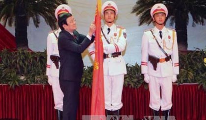 President Truong Tan Sang pins the Gold Star Order on the traditional flag of Vietnam People's Police Force (Photo: VNA)