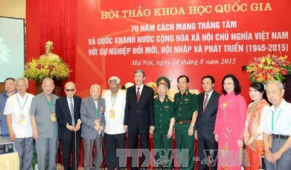 Politburo member Dinh The Huynh and delegates at the symposium (Photo: VNA)