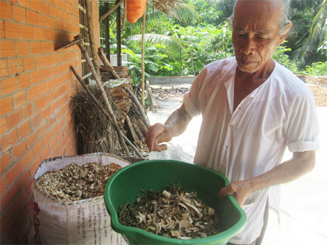 Ông Nguyễn văn Tư đang bốc thuốc cho bệnh nhân.