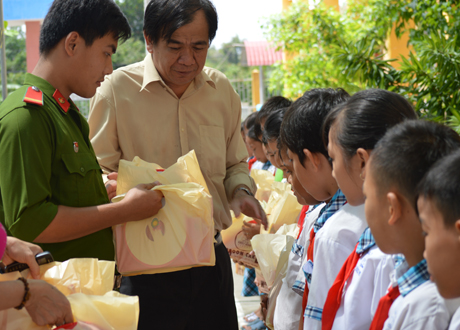 Ông Nguyễn Minh Tân, Phó Tổng Biên tập Báo Ấp Bắc và các đồng chí đoàn viên Cảnh sát PCCC&CNCH trao quà cho các em ở xã Hậu Mỹ Trinh.