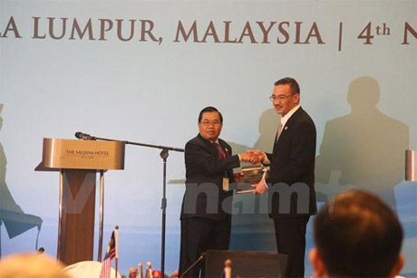 Bộ trưởng Quốc phòng Malaysia Hishammuddin Hussein (phải) chuyển giao chức Chủ tịch ADMM cho Phó Thủ tướng, Bộ trưởng Quôc phòng Lào Sengnouane Sayalat. Ảnh: Kim Dung-Trí Giáp/Vietnam+