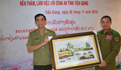 Đại tá Nguyễn Hữu Trí, Giám đốc Công an tỉnh Tiền Giang tặng quà lưu niệm cho Thiếu tướng Sỉ Phăn Vông Hương Khăm, Giám đốc Công an tỉnh Chăm Pa Sắc.