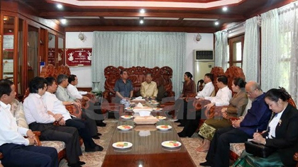 The Vietnamese delegation visits former Politburo member Saman Vinhaket. (Credit: VNA)