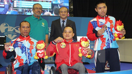 Nguyen Binh An (centre) wins a gold medal in powerlifting on December 5 (Photo: VNA)