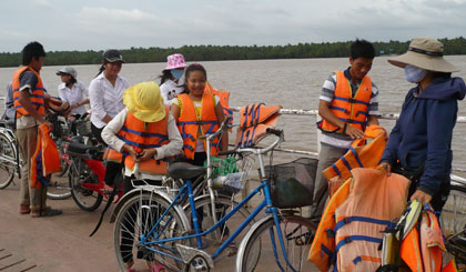 Phát áo phao cho học sinh qua phà.							              Ảnh: N.H 