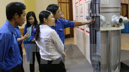 Students are examining a model of a nuclear reactor displayed in an exhibition in Nha Trang city, Khanh Hoa province. (Source: VNA)