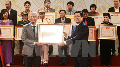 President Truong Tan Sang (R) presents People’s Artist title to artists (Source: VNA)