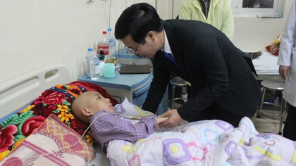 Politburo member Vo Van Thuong visits and presents gifts to a child patient at K Hospital. (Credit: dangcongsan.vn)