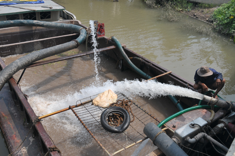 Người dân xã Tam Bình, huyện Cai Lậy dùng sà lan để chở nước ngọt tưới cây.