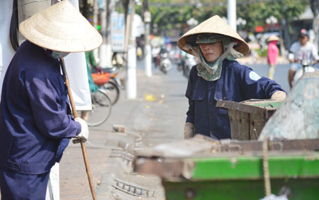 Hình dáng  của những  công nhân  vệ sinh  môi trường miệt mài  quét dọn  đường phố  để chào  ngày mới.