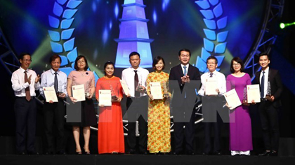 President Tran Dai Quang (fourth, right) and Chairman of the Party Central Committee's Information and Education Commission Vo Van Thuong (first, left) and the A prize winners (Photo: VNA)