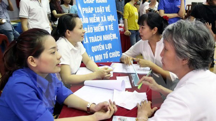 Vietnam focuses on expanding social insurance coverageConsultants (L) give advice on social insurance (Photo: VNA)