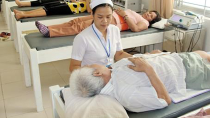 A nurse tends to an elderly (Photo: VNA)