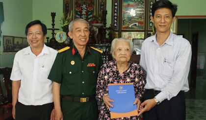 Ông Nguyễn Xuân Bình, Phó Chủ tịch Công đoàn Cty Xăng dầu Tiền Giang (phải) Trao 10 triệu đồng tặng mẹ Lê Thị Mười