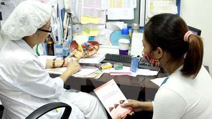 A doctor is advising a patient on screenings and diagnostic tests. (Credit: VNA)