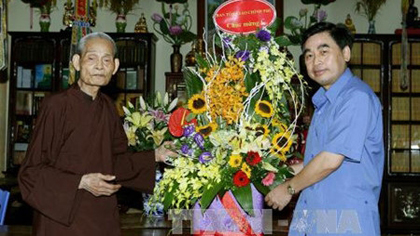 Vice Chairman of the Government’s Religious Affairs Committee Duong Ngoc Tan presents flowers to a Buddhist dignitary (Credit: VNA)