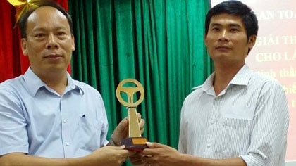 Phan Van Bac (right) receives the ‘Golden Wheel’ title of this year for his bravery. (Credit: NDO)