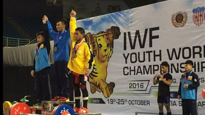 Le Nguyen Quoc Bao (centre) and his two runners-up on a podium receiving their medals of the International Weightlifting Federation Youth World Championship in Malaysia. ​(Source: VNA)