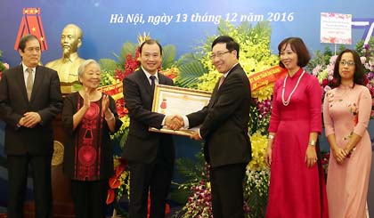 Deputy PM and FM Pham Binh Minh (right) presents the Labour Order, first class, to the Department of Information and Press.
