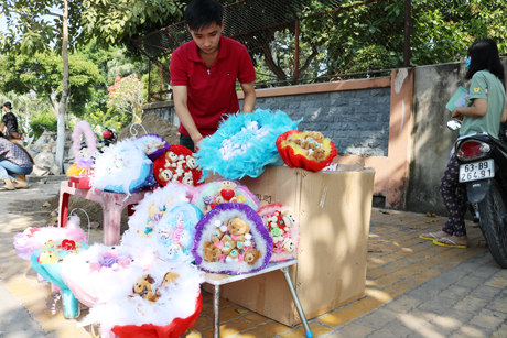 Bạn Lê Quang Minh (sinh viên Trường Đại học Tiền Giang) tranh thủ bán quà tặng nhân Ngày lễ Tình Nhân (trên vỉa hè đường Lý Thường Kiệt, TP. Mỹ Tho) để kiếm thêm chút ít thu nhập và mang niềm vui đến cho mọi người,