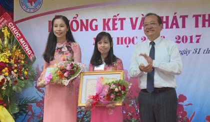 Deputy Chairman of the Provincial People’s Committee Tran Thanh Duc presents award to excellent teachers. Photo: thtg.vn