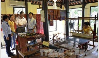 A Khmer artisan from Tinh Bien district, An Giang province making a brocade product at the event (Photo: VNA)