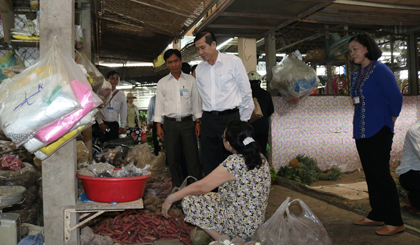 Ông Lê Văn Hưởng, Chủ tịch UBND tỉnh kiểm tra một quầy sạp bán hàng nông sản là các loại củ ở chợ TX. Gò Công