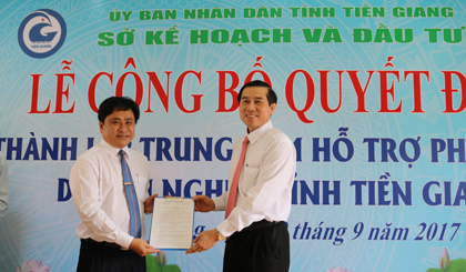 Ông Lê Văn Hưởng, Chủ tịch UBND tỉnh (bên phải) trao Quyết định của UBND tỉnh Tiền Giang về thành lập Trung tâm Hỗ trợ phát triển doanh nghiệp tỉnh Tiền Giang cho ông Trần Văn Dũng, Giám đốc Sở Kế hoạch và Đầu tư