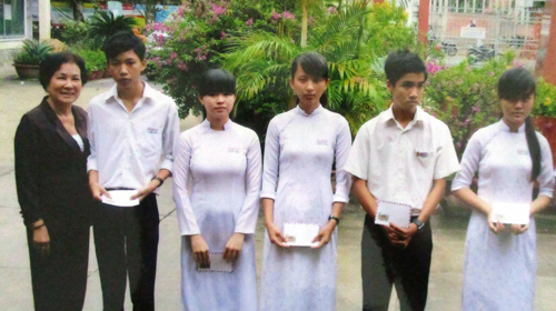 Cô Trần Thị Bé (bìa trái) trao học bổng cho học sinh vượt khó.