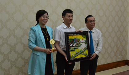 Deputy Chairman of the PPC Pham Anh Tuan presents souvenir to Mayor Chen Yan. Photo: THU HOAI