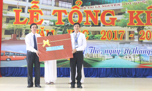 Secretary of the Tien Giang provincial Party Committee Nguyen Van Danh hands over present to the school.