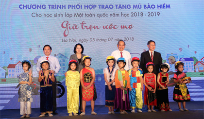 Phó Thủ tướng Trương Hoà Bình và Phó Chủ tịch nước Đặng Thị Ngọc Thịnhtặng MBH đạt chuẩn cho đại diện các cháu học sinh lớp 1. Ảnh: VGP/Lê Sơn