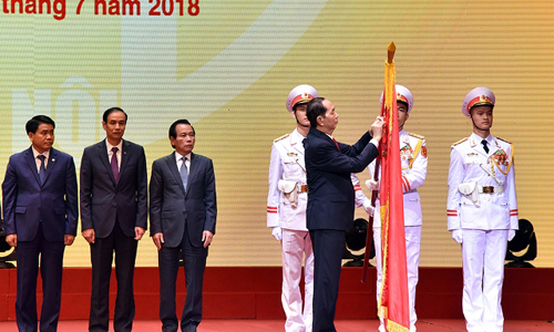 President Tran Dai Quang pins the first-class Independence Order on Hanoi’s traditional flag. (Photo: NDO/Duy Linh)