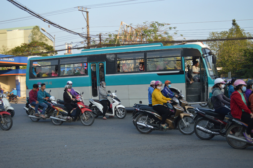 Cửa xe lúc nào cũng mở để cho công nhân dễ dàng xuống xe dù chạy trên QL 1A. Ảnh: BẢO LAM