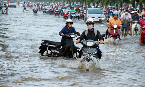 Vehicles wade through floodwater on Nguyen Van Cu street of Ninh Kieu district, the Mekong Delta city of Can Tho. Tidal surge has seriously flooded many streets in Can Tho since early October (Photo: VNA)