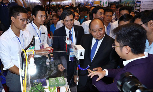 Prime Minister Nguyen Xuan Phuc (second from right) visits an exhibition booth at Techfest 2018's opening ceremony (Photo: VNA)