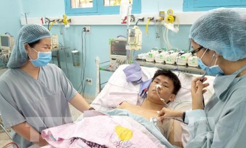 Dinh Viet Huy is cared for by medical staff at the Nhi Dong 2 Hospital in Ho Chi Minh City (Photo: VNA)