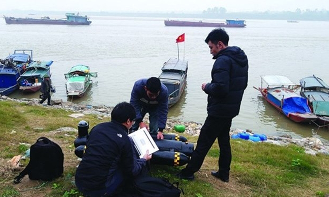 Researchers from the ViInstitute of Geodesy and Cartography prepare to test their seafloor mapping vehicle by the Red River. (Photo: baotainguyenmoitruong.vn)