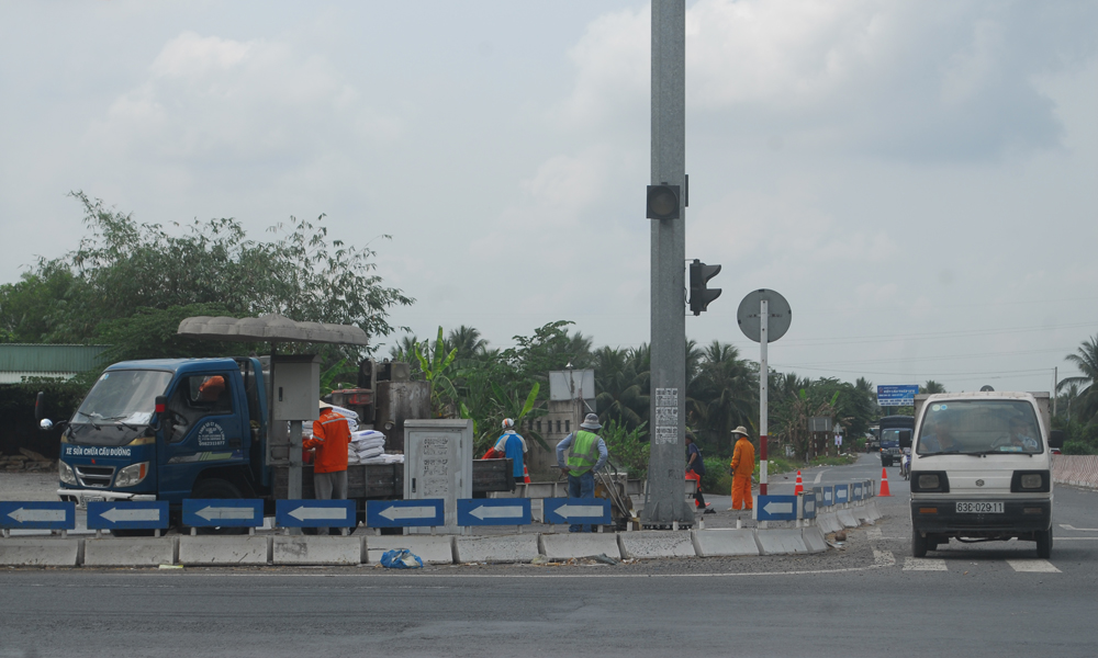 Công nhân của công ty đang chỉnh trang lại đường vào tuyến tránh TX. Cai Lậy (phía xã Tân Hội) vào trưa 22-3.