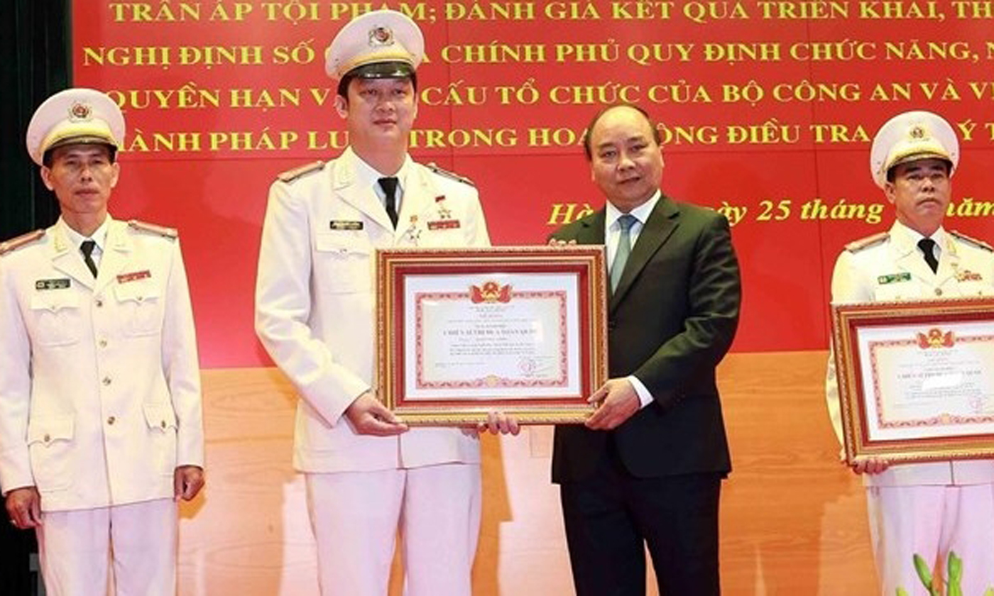 Prime Minister Nguyen Xuan Phuc (second from right) presents certificates of merits to outstanding public security officers (Source: VNA)