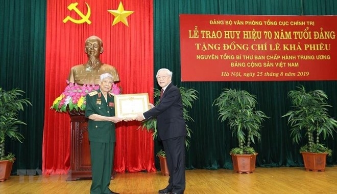  Party General Secretary and President Nguyen Phu Trong (R) presents a 70-year Party membership badge to former Party General Secretary Le Kha Phieu (Photo: VNA)