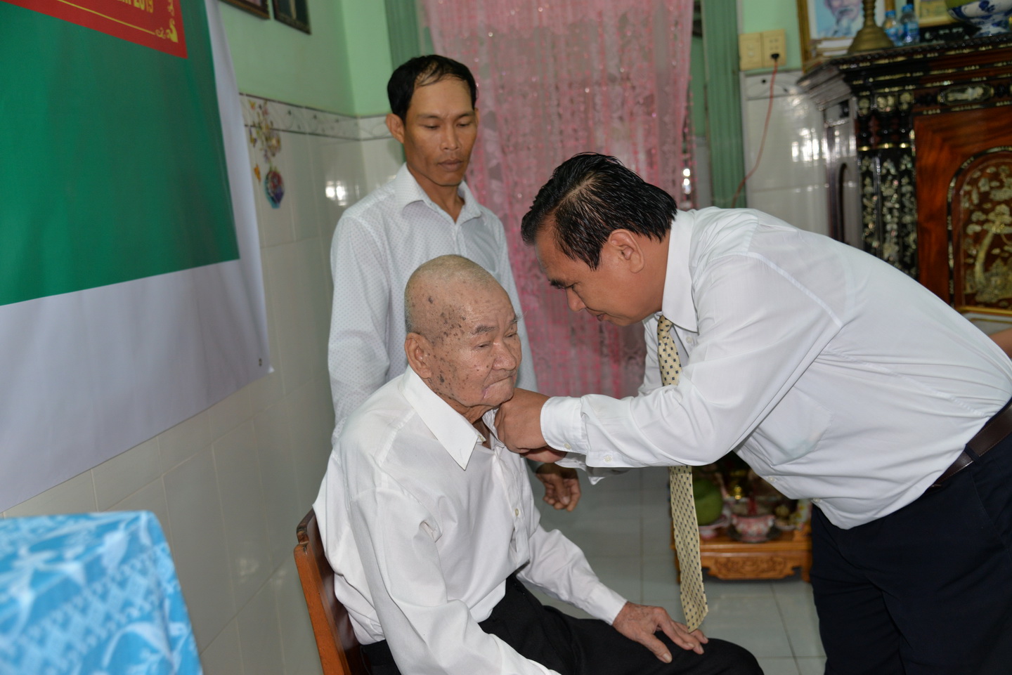  Standing Deputy Secretary of the Provincial Party Committee Vo Van Binh presents the 70-year Party membership badge to party member Le Van Nam