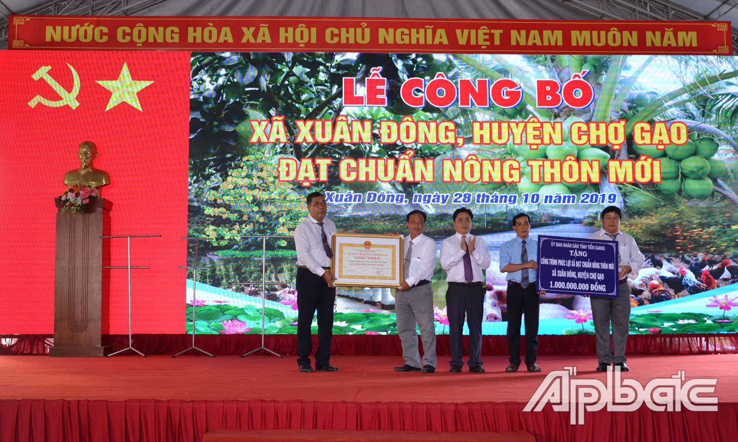 Phó Chủ tịch UBND tỉnh Trần Văn Dũng trao Bằng công nhận xã Xuân Đông đạt chuẩn NTM và bảng tượng trưng công trình phúc lợi.