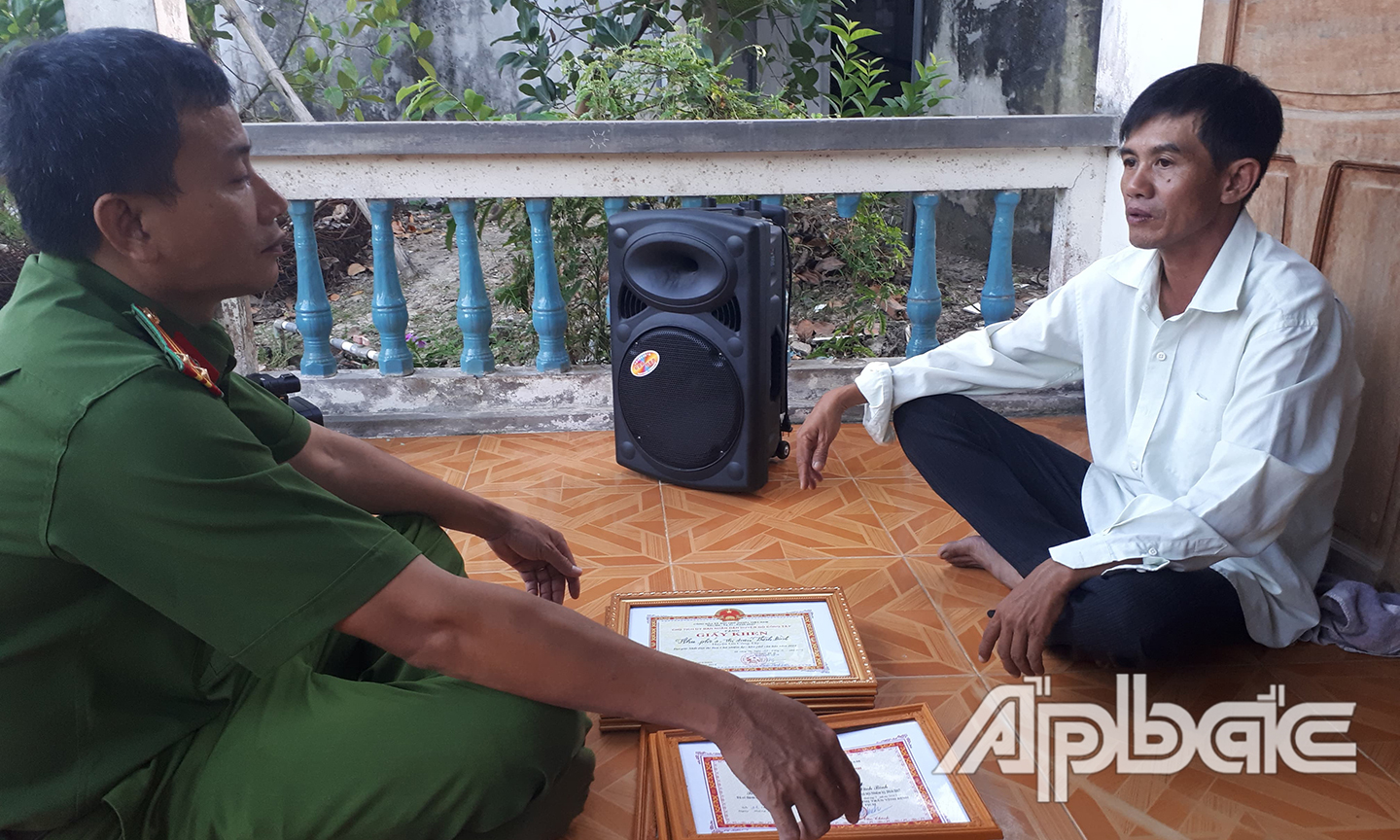 Anh Khưu Đạt Hùng trao đổi về nhiệm vụ giữ gìn ANTT trên địa bàn khu phố cùng Cảnh sát khu vực.                                                                                         Ảnh: THANH VIỆT