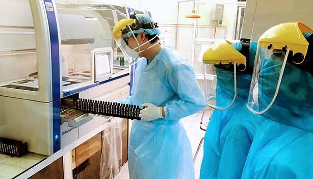 Health workers in Hai Phong City operate an automatic Real time RT-PCR molecular biology machine to serve COVID-19 testing. (Photo: NDO/Ngo Quang Dung)