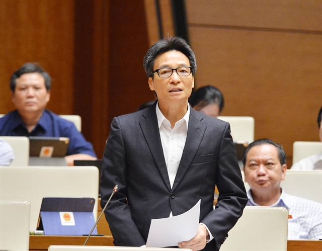 Deputy Prime Minister Vu Duc Dam addresses the National Assembly meeting to discuss socio-economic performance on Saturday. 